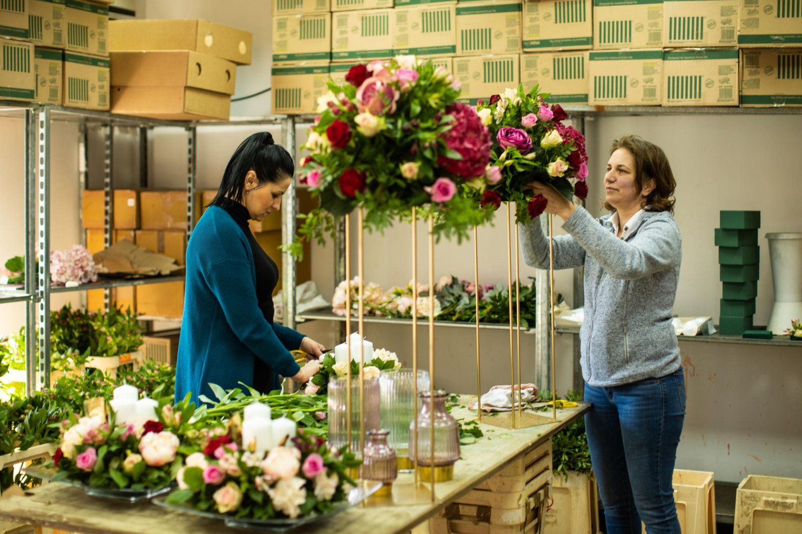 Wedding flower arrangements staged in buckets and containers before event installation